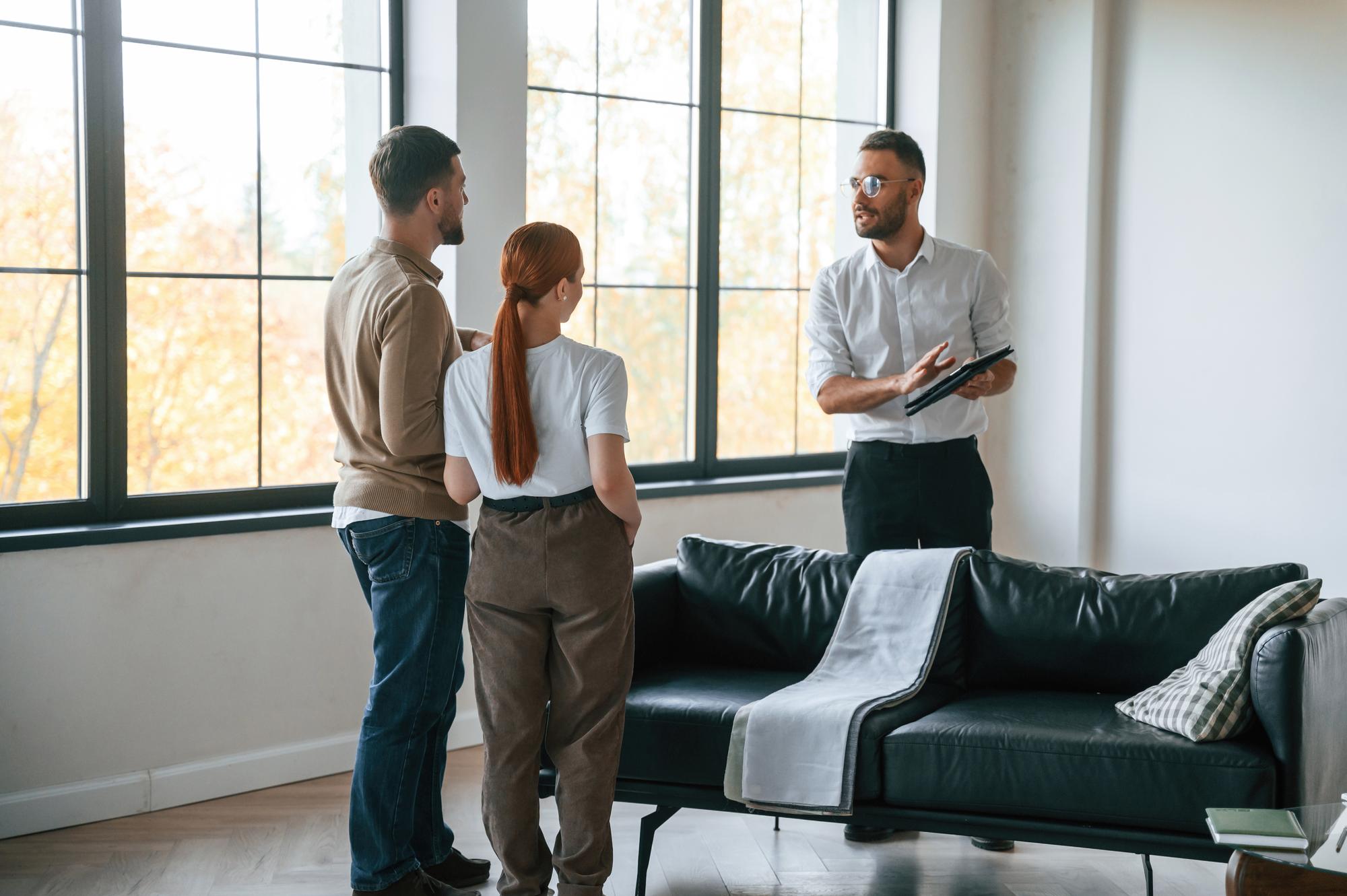 agent imobiliar discutând cu proprietarul în living